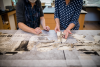 Conservators examine a circus posted in shredded pieces